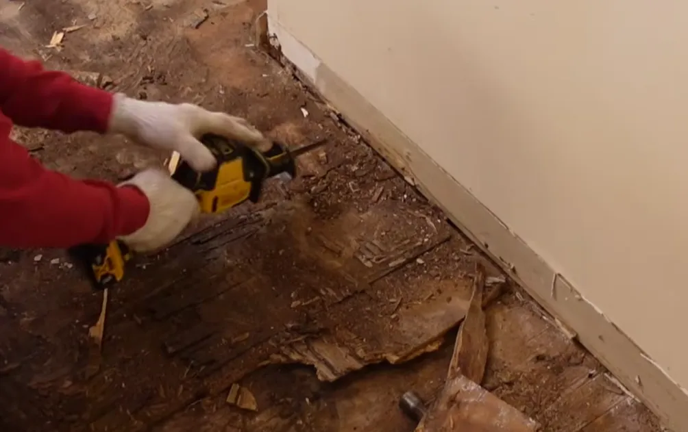 Technician cutting out a damaged subfloor during water damage repair in Lincoln, NE